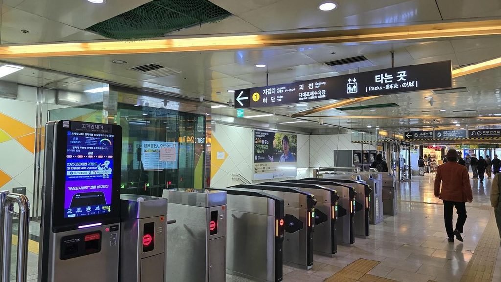 Traveler using a transportation card at a Busan subway station